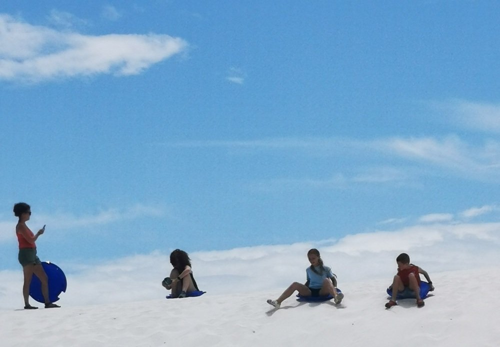 Children sledding in White Sands National Park